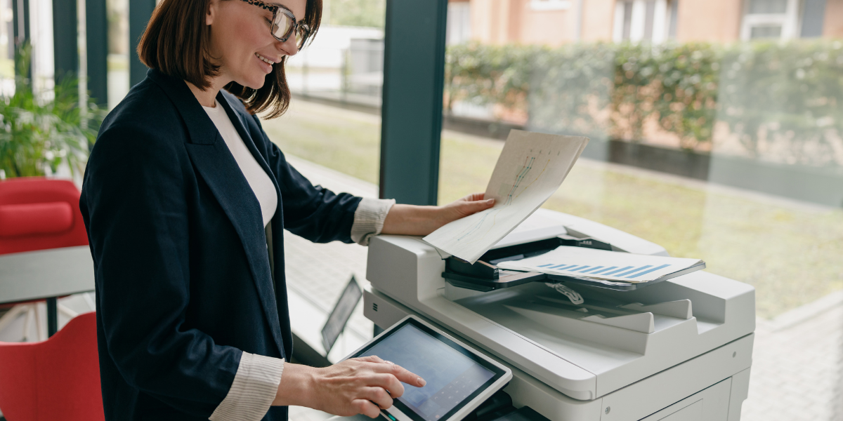 Businesswoman using an MFP to make copies.