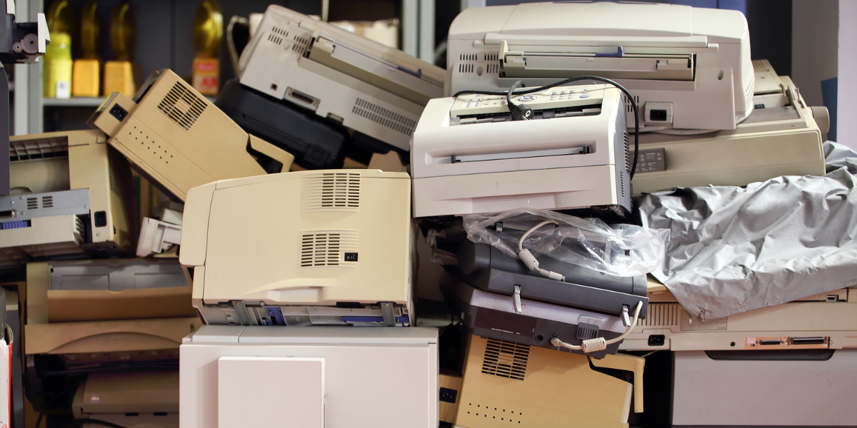 old, stacked up printers ready for printer disposal