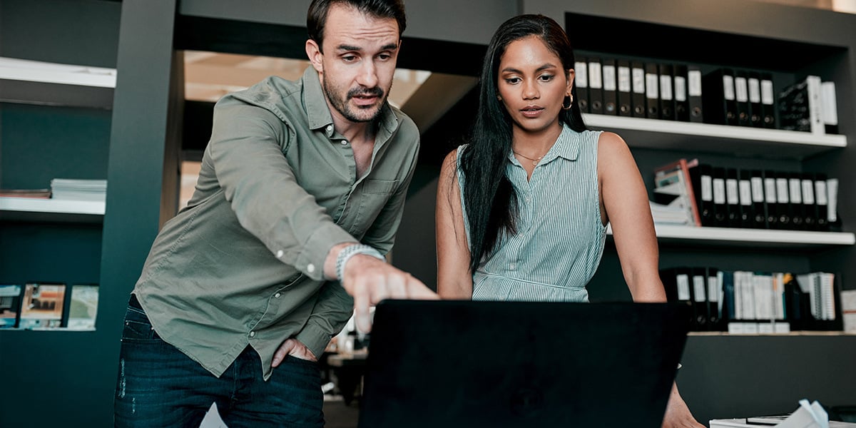 two young small business owners looking at laptop